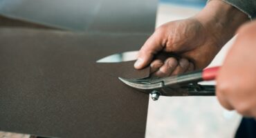 close up of a Worker hands use scissors to cut the metal sheet
