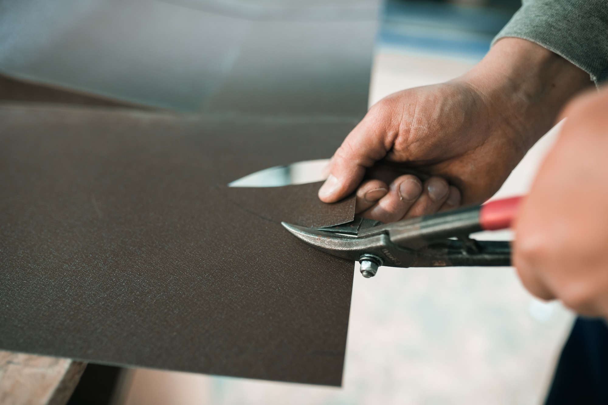 close up of a Worker hands use scissors to cut the metal sheet