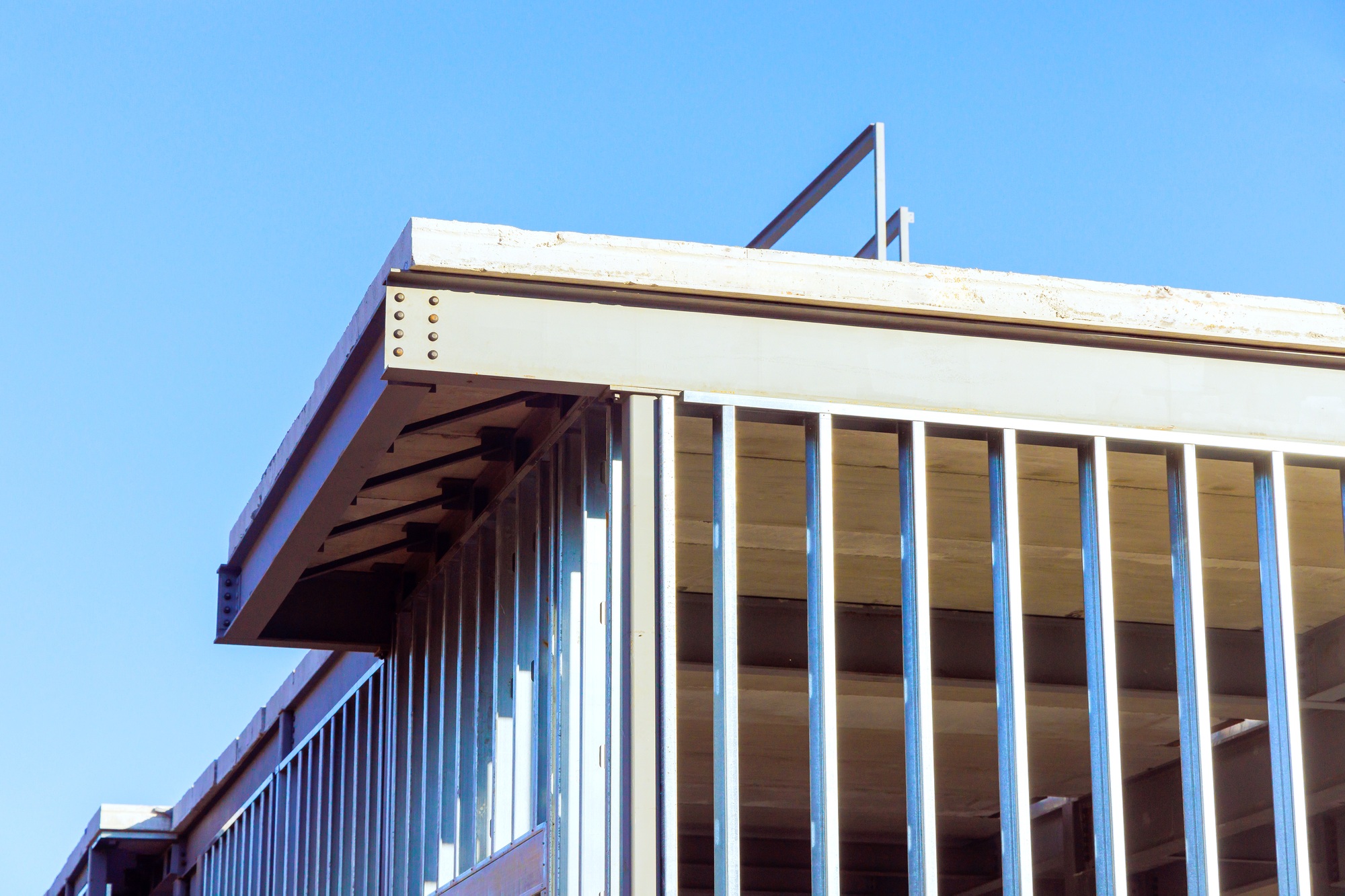 Under construction, steel beams frame a frame of an office building